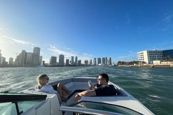 A couple on a private sunset cruise boat in Fort Lauderdale, waterfront mansions passing in the background as the sun sets over the intracoastal waterway