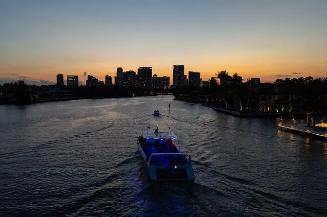 The Sea Rocket speedboat on a sunset intracoastal cruise in Fort Lauderdale, passing Fort Lauderdale Beach with the city skyline visible